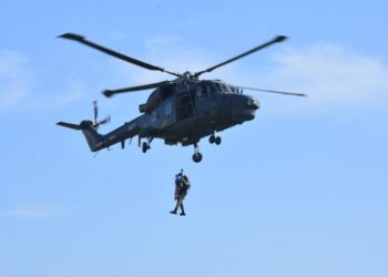 HELIKOPTER Super LYNX MK 100 menurunkan Kuartermaster Udara bersama stretcher bagi mengambil mangsa pada demonstrasi menyelamat di Lumut semalam. - UTUSAN/IHSAN TLDM
