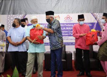 MAHDZIR Khalid menyampaikan bantuan kepada salah seorang peserta pada Majlis Iftar Warga FELCRA Padang Terap, Kedah semalam.