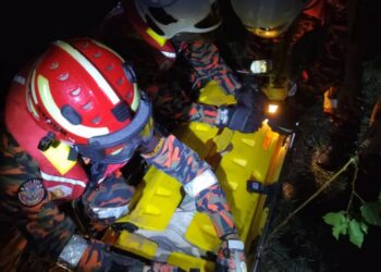ANGGOTA bomba membantu membawa mayat lelaki Orang Asli yang ditemukan lemas di Sungai Ulu Menderang, Sungkai semalam. - UTUSAN/IHSAN JBPM PERAK