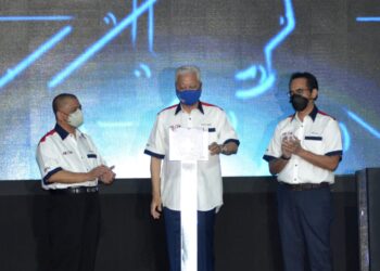 ISMAIL Sabri Yaakob (tengah) melakukan gimik pelancaran AHTV di Proton City, Tanjung Malim hari ini. - UTUSAN/ZULFACHRI ZULKIFLI