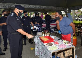 MIOR Faridalathrash Wahid (kiri) beramah mesra dengan peniaga pada Program Pemantauan SOP Covid-19 di Bazar Ramadan Stadium Indera Mulia di Ipoh hari ini. - UTUSAN/ZULFACHRI ZULKIFLI