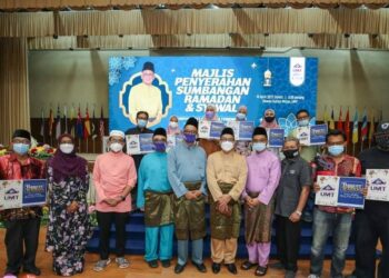 MAZLAN Abd. Ghaffar (lima, dari kiri) bersama penerima sumbangan selepas majlis berbuka puasa di Dewan Sultan Mizan, UMT di Kuala Nerus semalam.