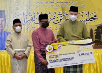 SULTAN Nazrin Muizzuddin Shah (kanan) menyampaikan replika cek sumbangan bantuan zakat kepada wakil penerima Daerah Kinta pada Majlis Sambutan Nuzul al-Quran peringkat negeri Perak di Masjid Sultan Azlan Shah, Ipoh semalam. - UTUSAN/ZULFACHRI ZULKIFLI
