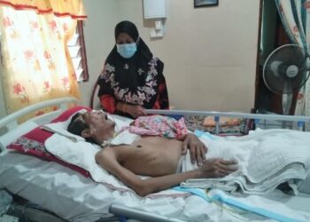 HASANAH Mahamud Yusoff melihat sayu  Mohd. Hamidi Khairudeen yang terlantar dan memerlukan alat bantuan pernafasan di Felda Kota Gelanggi Dua di Jerantut, Pahang. – UTUSAN/HARIS FADILAH AHMAD