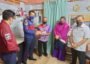 MOHD. Hairi Mad Shah (dua dari kiri) menyampaikan sumbangan kepada salah seorang penerima program Ihya Ramadan anjuran MSNJ di Johor Bahru, di sini.
