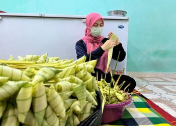 EMIZA Zulkifli tidak menang tangan menyiapkan tempahan satu tan metrik atau lebih 35,000 biji ketupat palas sempena sambutan Aidilfitri tahun ini di kediamannya di Taman Pauh Indah, Arau, Perlis semalam.- UTUSAN/MOHD. HAFIZ ABD. MUTALIB
