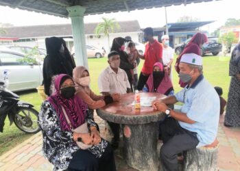 MOHAMED Hamidi Mohd. Alias dan Zairinah Abdullah menunggu jenazah dua cucu mereka di Jabatan Forensik, Hospital Changkat Melintang dekat Parit hari ini. - UTUSAN/MOHAMAD HAFIZI MOHD. SAID