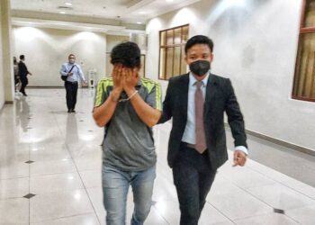 TERTUDUH, Muhammad Aizat Ziadi (kiri) dibawa keluar dari Mahkamah Sesyen Kuantan di Kuantan, Pahang. - UTUSAN/ DIANA SURYA ABD WAHAB