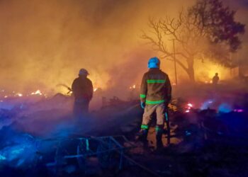 ANGGOTA bomba memadam kebakaran yang berlaku di penempatan sementara Kampung Bangau-Bangau, Semporna semalam. - IHSAN BOMBA