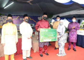 DR. Haim Hilman Abdullah menyampaikan replika cek kepada wakil pelajar yang menerima zakat bantuan sara hidup pada Majlis Iftar Perdana UUM,  Sintok, Kubang Pasu semalam. - UTUSAN/MOHD. RAFIE AZIMI