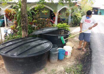 MUHAMMAD Hakimi Halim membersihkan tangki air sebagai persediaan mengisi air bagi menampung keperluan pada Aidilfitri di Kampung Segantang Garam, Merbok, Sungai Petani. - UTUSAN/OTHMAN YAHAYA