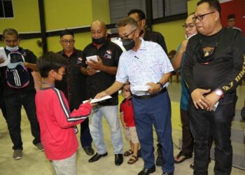 ISMAIL Abdul Muttalib (dua kanan) menyampaikan sumbangan duit raya kepada anak yatim pada program Iftar Ramadan Maran Bikers dan Singapore Biker bersama 183 anak yatim dan 117 ibu tunggal di Dewan Terbuka Tengku Muda Pahang di Maran, Pahang. - UTUSAN/SALEHUDIN MAT RASAD