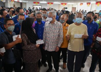 ISMAIL Sabri Yaakob (tengah) berbual bersama sebahagian bekas pekerja Perwaja Steel Sdn. Bhd. selepas menyampaikan pampasan di Pejabat UMNO Kemaman di Kemaman hari ini. - UTUSAN/PUQTRA HAIRRY ROSLI