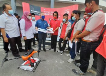 DR. Adham Baba (tiga kiri) bersama Norlizah Noh melihat dron ketika hadir pada program CSR Sekolah Angkat 'Fly With Meraque' di Dewan Majlis Daerah Kota Tinggi, Bandar Tenggara hari ini.