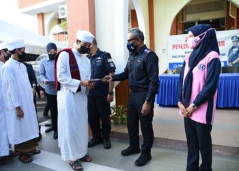 RAMLI Mohamed Yoosuf (dua dari kanan) menyampaikan sumbangan kepada pelajar tahfiz sempena Program Pencegahan Jenayah Ketua Polis Pahang Bersama Masyarakat Daerah Pekan di perkarangan Masjid An-Nur Kampung Ketapang Hilir, di Pekan, Pahang.- UTUSAN/NORHAFIZAN ZULKIFLI