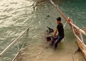 TANGKAP layar daripada video menunjukkan seorang penduduk menyelamatkan sebuah motosikal yang hampir tenggelam selepas jambatan di jeti Bagan Pauh, Pulau Tuba, Langkawi runtuh, petang semalam.