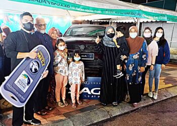 MUHAMMAD Rozairen Hairudin (kiri sekali) bersama ahli keluarganya bergambar di hadapan kereta Proton Saga yang dimenangi menerusi cabutan bertuah Melgrab di Jalan Hang Tuah, Melaka. - UTUSAN/AMRAN MULUP