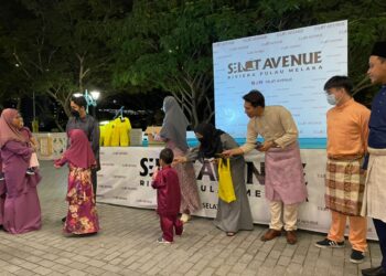 MUHAMMAD AFIQ Ikhwan memberikan duit raya kepada anak-anak di bawah jagaan JKM Melaka dalam satu majlis yang diadakan di Selat Avenue Riviera, Pulau Melaka, Melaka. - UTUSAN/DIYANATUL ATIQAH ZAKARYA