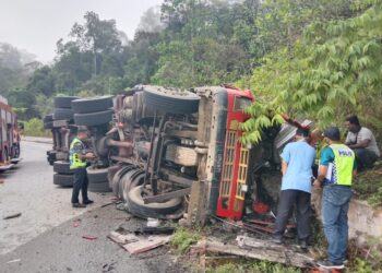 ANGGOTA polis dan seorang paramedik memeriksa dalam lori treler yang melibatkan dua maut dalam kemalangan di Kilometer 55, Jalan Persekutuan Lama Lipis ke Merapoh di Lipis, Pahang. - FOTO/IHSAN IPD LIPIS