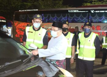 AZMIL Zainal Adnan (tengah) memeriksa cukai jalan sebuah kenderaan ketika Operasi Bersepadu sempena sambutan Hari Raya Aidilfitri di Plaza Tol Skudai, Johor Bahru di sini.
