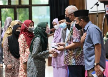MAHDZIR Khalid (dua dari kanan) menyampaikan sumbangan kepada pelajar pada Program Ceria Ke Sekolah dan Majlis Perasmian Projek Baiti Jannati TNB di Kuala Nerang, Padang Terap,  semalam. - UTUSAN/JAMLIAH ABDULLAH