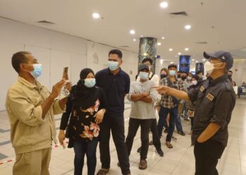 HERMONO (kanan) meluangkan masa beramah mesra dengan warga Indonesia yang mahu membeli tiket untuk pulang melalui Terminal Feri Antarabangsa Stulang Laut, Johor Bahru, di sini hari ini.