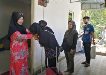 LATIFAH Abd. Rahman (kiri) menyambut kepulangan anak kelimanya, Nur Sukriyah Risman, 32, di rumahnya di Kampung Pela, Hulu Terengganu, semalam. - UTUSAN/NOOR HAYATI MAMAT