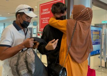 MASRIKA Sukeme memeluk Syafiq Aditya Ababil sejurus selepas anaknya itu tiba di balai ketibaan ICQS, Melaka. - UTUSAN/DIYANATUL ATIQAH ZAKARYA