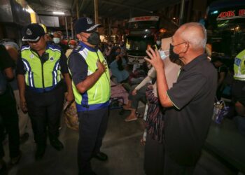 MOHD. Rosdi Daud (dua kiri) berbual dengan orang awam di teminal bas di Lembah Sireh, Kota Bharu. - UTUSAN/ROHANA MOHD. NAWI