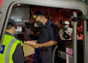 MUHAMMAD Firdaus Shariff (kanan) memeriksa dokumen perjalanan bas ekspres di Terminal Melaka Sentral, Melaka. - UTUSAN/DIYANATUL ATIQAH ZAKARYA