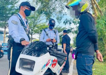 ANGGOTA trafik memeriksa penunggang motosikal pada Operasi Bersepadu Enam Kesalahan Utama Lalu Lintas bersama Agensi Antidadah Kebangsaan (AADK) di Jalan Maxwell, Ipoh semalam. - UTUSAN/ASLIZA MUSA