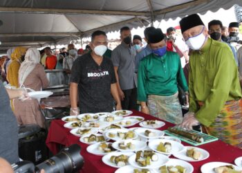 ISMAIL Sabri Yaakob (kanan) memotong lemang pada Rumah Terbuka Aidilfitri Parlimen Bera di Dataran Kerayong di Bera, Pahang. - UTUSAN/SHAIKH AHMAD RAZIF