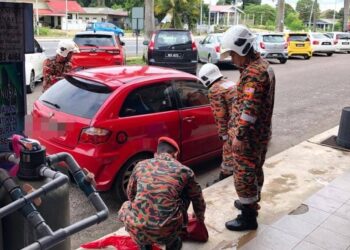 SEPASUKAN anggota bomba menggunakan peralatan khas untuk membuka pintu Proton Satria yang terkunci di Taman Samudera Timur, Chukai, di Kemaman hari ini.