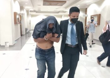 TERTUDUH, Abdul Wahab Musa dibawa keluar dari Mahkamah Sesyen Kuantan selepas mengaku tidak bersalah menerima suapan di Kuantan, Pahang. - UTUSAN/DIANA SURYA ABD WAHAB