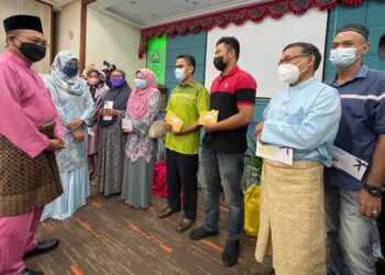 AWANG Hashim (kiri) beramah mesra bersama 13 orang berinsurans yang menerima bayaran faedah pada Majlis Sambutan Hari Raya Aidilfitri Perkeso di Wisma Perkeso Kedah di Alor Setar Kedah hari ini. - UTUSAN/JAMLIAH ABDULLAH