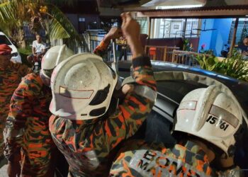 ANGGOTA bomba menggunakan peralatan khas untuk mengeluarkan seorang kanak-kanak yang terkunci dalam kereta di Taman Limbongan Permai, Melaka. - UTUSAN/DIYANATUL ATIQAH ZAKARYA