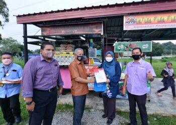 MOHD. Zamri Mohd. Esa menyerahkan lesen penjaja kepada salah seorang penerima dalam Program Sesi Penyerahan Lesen Penjaja dan Sesi Ramah Mesra Bersama Penyewa-penyewa Tapak Penjaja Berpusat MPPD di Bagan Pinang, Port Dickson hari ini. - UTUSAN/ MOHD. SHAHJEHAN MAAMIN