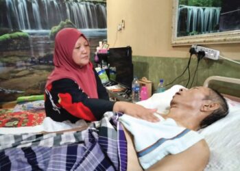 KAMSIAH Khalil setia di sisi suaminya, Shahrudin Mustafa atau Atan yang diserang angin ahmar di rumah mereka di Taman Selesa Jaya, Kampung Parit Patah, Pontian, Johor. – UTUSAN/MUHAMMAD ZIKRI