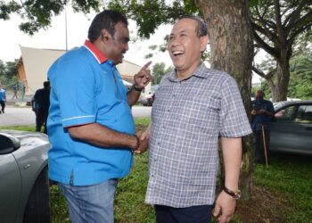 AMINUDDIN Harun berseloroh dengan M. Ravi ketika masing-masing yang merupakan lawan bagi merebut Ketua Cabang Port Dickson dalam Pemilihan PKR 2022 terserempak di tempat pengundian secara fizikal di Dewan Bandar Springhill, Port Dickson hari ini. - UTUSAN/MOHD. SHAHJEHAN MAAMIN