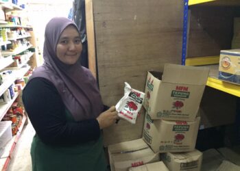 NOR Haliza Harun menunjukkan bekalan tepung yang berkurangan di kedai runcitnya di Kuala Terengganu, hari ini. -TENGKU DANISH BAHRI TENGKU YUSOFF