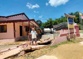 RAZALI Md. Zin menunjukkan tembok pagar Masjid Kariah Kampung Kabung, Inas, Johol, Kuala Pilah yang roboh dalam kejadian banjir di perkampungan berkenaan kelmarin. - UTUSAN/NOR AINNA HAMZAH