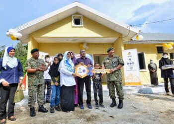 DZULKARNAIN Ahmad (kanan) dan Haniza Mohamed Talha (empat dari kiri) menyerahkan replika kunci kepada Mohamad Sahil Mat Said pada Majlis Serah Kunci Rumah-Bina Baharu Menerusi Inisiatif Perumahan Veteran ATM di Kampung Sarin, Kuala Klawang, Jelebu. Negeri Sembilan. - UTUSAN/MOHD. SHAHJEHAN MAAMIN