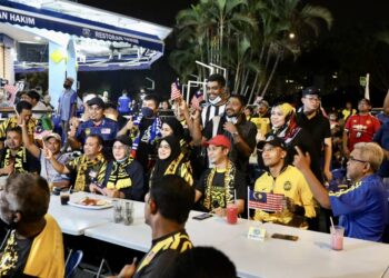 HALIMAH Mohamed Sadique (duduk, empat kiri) bersama penyokong Harimau Muda hadir menyaksikan perlawanan bola sepak separuh akhir dalam Sukan Sea Ke-31 diantara Malaysia menenteng Vietnam menerusi skrin gergasi di Restoran Hakim Seksyen 7, di Shah Alam, Selangor, malam tadi. - UTUSAN / ZULFADHLI ZAKI