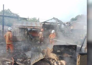 ANGGOTA bomba berusaha memadamkan kebakaran melibatkan sebuah rumah di Kampung Baru Air Kuning Selatan, Gemencheh, Tampin pagi tadi.-GAMBAR/IHSAN BOMBA