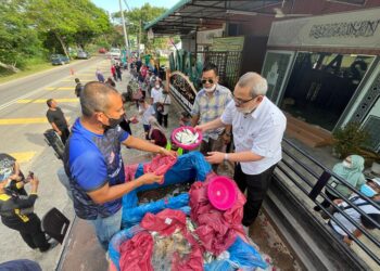 DZULKIFLI Ahmad (dua dari kiri) turut mengagihkan lebih satu tan ikan percuma kepada penduduk di sekitar Tasek Gelugor di Maahad Tahfiz As Syafee (Matas), Lubuk Meriam, Pulau Pinang hari ini.