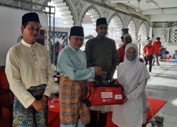 NAJMI Ahmad (dua dari kiri)) menyampaikan beg kepada seorang  jemaah haji  yang menyertai majlis  penutupan  Kursus Perdana Haji 2022 di Masjid Zahir, Alor Setar, hari ini. - UTUSAN/MOHD. RAFIE AZIMI