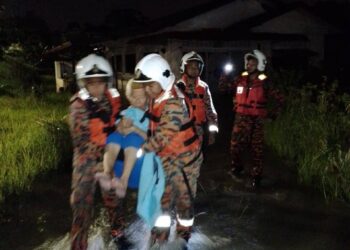 ANGGOTA bomba menyelamatkan seorang warga emas yang terlibat kejadian banjir kilat di Taman England, Sikamat, Seremban malam tadi.