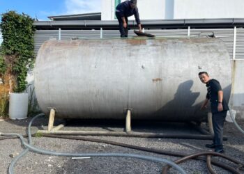 ANGGOTA penguat kuasa Kementerian Perdagangan Dalam Negeri dan Hal Ehwal Pengguna (KPDNHEP) Melaka menunjukkan tangki tambahan lori yang dirampas dalam serbuan di Kawasan Perindustrian Krubong, Melaka. - UTUSAN/DIYANATUL ATIQAH ZAKARYA