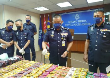 KAMARUL Zaman Mamat (dua kanan) menunjukkan dadah yang dibungkus dalam paket minuman sebelum dijual pada harga RM250 sebungkus dalam sidang akhbar di IPK Johor, di sini hari ini.