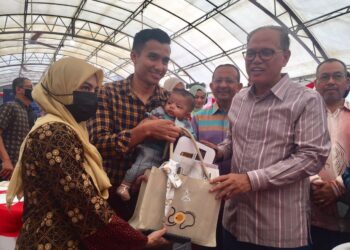 WAN ROSDY Wan Ismail (kanan) menyampaikan insentif sumbangan RM200 dan barangan keperluan bayi pada majlis pelancaran Program Anak Kebanggaan Pahang 2022 (Pahang Pride Kid 2022) di Taman Bandar, Indera Mahkota di Kuantan, Pahang. - UTUSAN/ DIANA SURYA ABD WAHAB